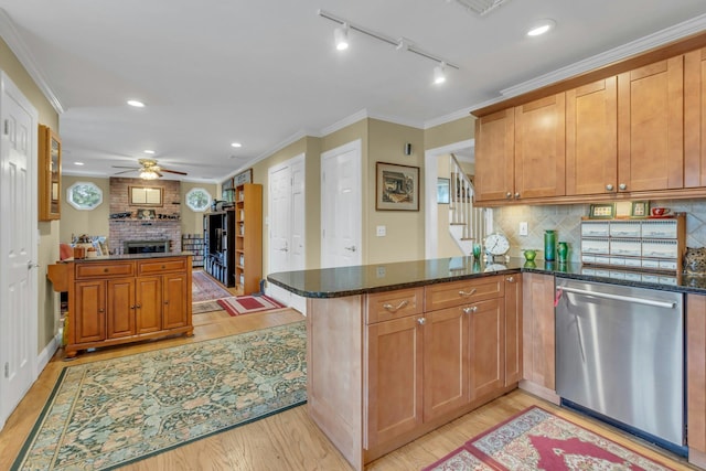 kitchen featuring stainless steel dishwasher, dark stone counters, and kitchen peninsula