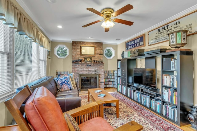 living room featuring hardwood / wood-style flooring, ceiling fan, ornamental molding, and a brick fireplace