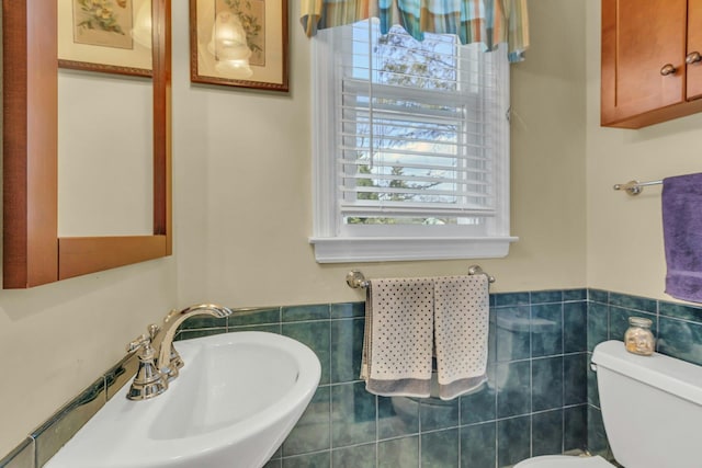 bathroom with tile walls, sink, and toilet