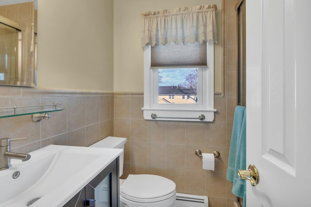 bathroom with tile walls, sink, a baseboard radiator, and toilet