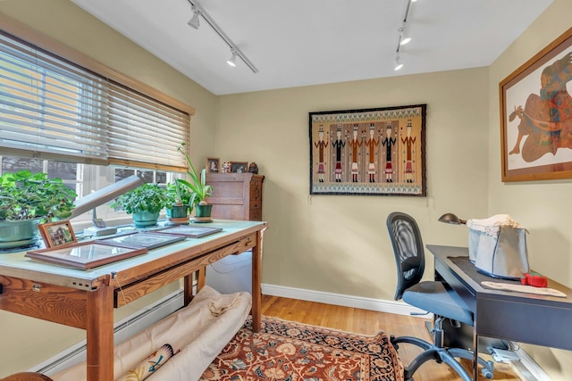 office space with hardwood / wood-style flooring and rail lighting