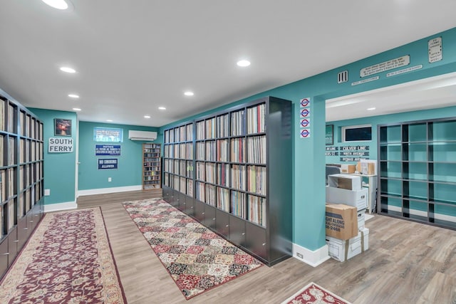 hall featuring wood-type flooring and a wall unit AC