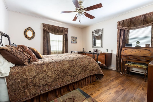 bedroom with dark hardwood / wood-style flooring, ornamental molding, and ceiling fan