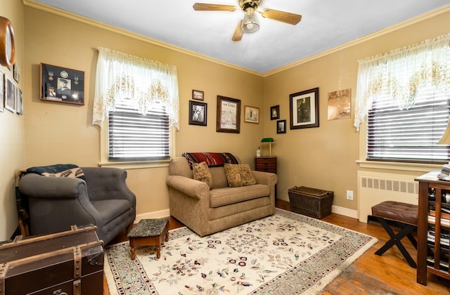 sitting room with radiator, hardwood / wood-style flooring, ornamental molding, and ceiling fan