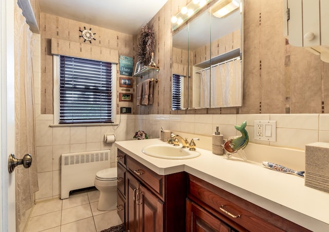 bathroom with tile patterned floors, toilet, tile walls, radiator heating unit, and vanity