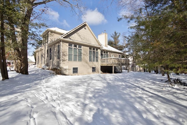 snow covered property featuring a chimney