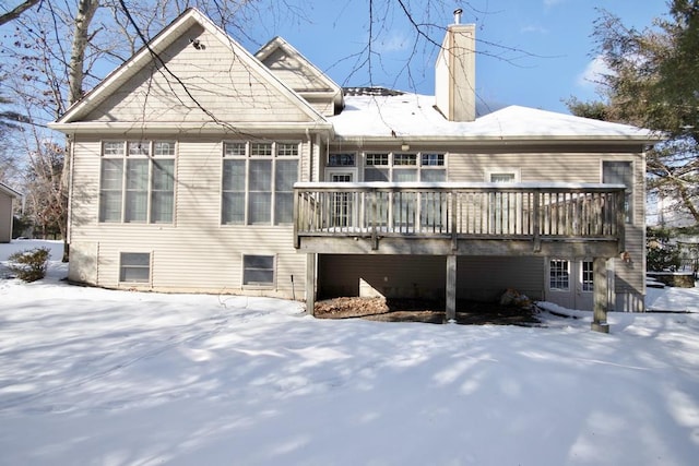 snow covered property with a chimney and a deck