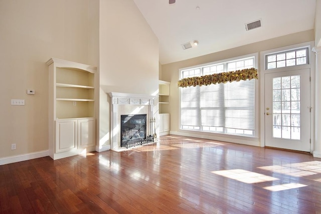 unfurnished living room featuring high vaulted ceiling, visible vents, wood finished floors, and a high end fireplace