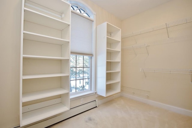 spacious closet featuring baseboard heating and carpet flooring