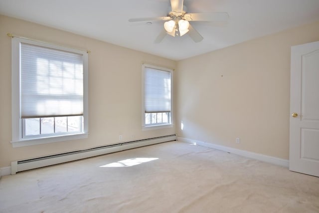 spare room with light carpet, ceiling fan, a baseboard radiator, and baseboards