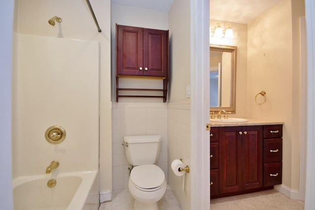 bathroom with toilet, a wainscoted wall, vanity, tile walls, and shower / bathing tub combination