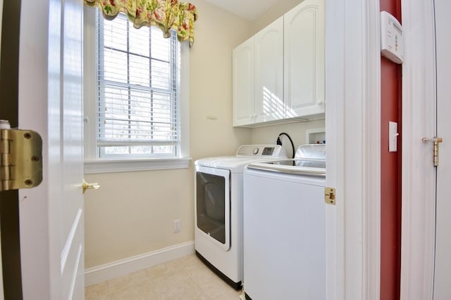 washroom featuring cabinet space, washer and clothes dryer, baseboards, and light tile patterned flooring