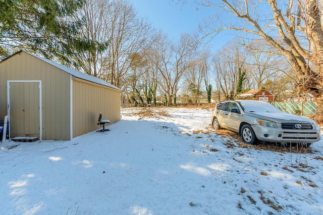 yard layered in snow featuring an outbuilding