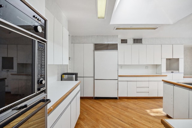 kitchen featuring white cabinetry, light wood-type flooring, and built in refrigerator