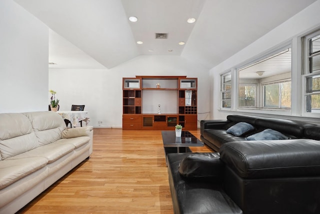 living room featuring lofted ceiling and light hardwood / wood-style floors