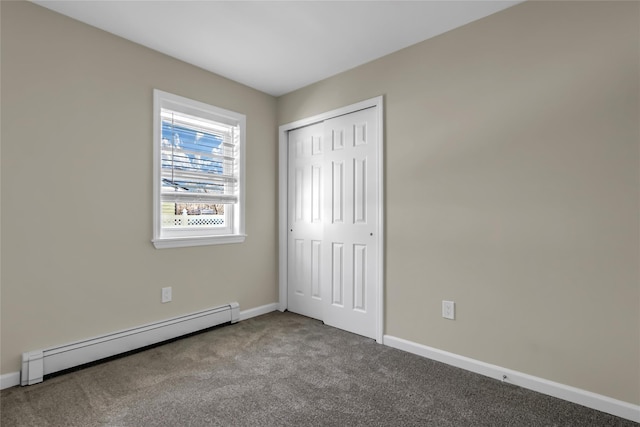 unfurnished bedroom with a baseboard radiator, carpet floors, and a closet