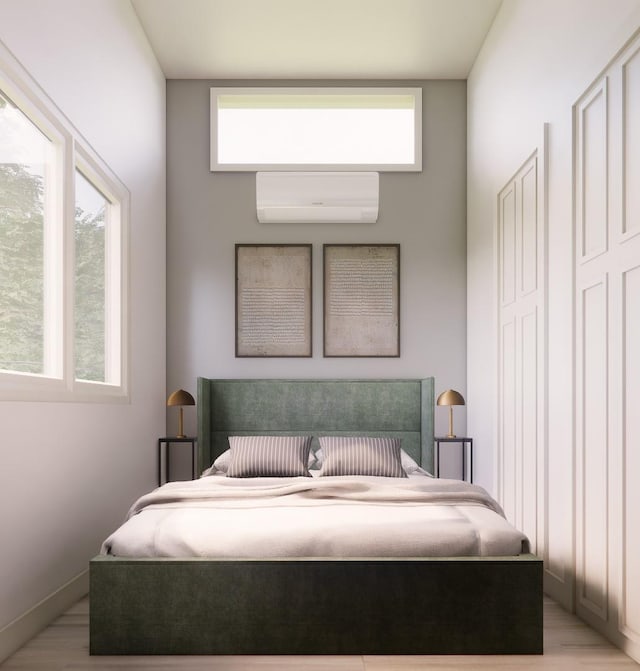 bedroom with a wall unit AC and light wood-type flooring