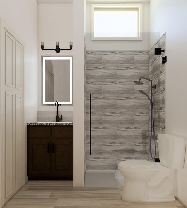 bathroom with tiled shower, vanity, and toilet