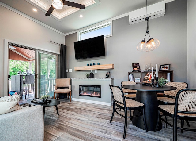 197 Wheeler Rd, Florida, NY 10921 - dining space featuring an AC wall unit, ceiling fan, wood finished floors, a high ceiling, and a glass covered fireplace