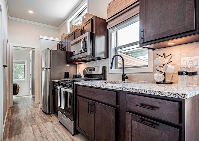 197 Wheeler Rd, Florida, NY 10921 - kitchen with stainless steel appliances, backsplash, dark brown cabinetry, ornamental molding, and light wood-style floors