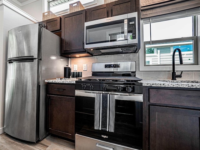197 Wheeler Rd, Florida, NY 10921 - kitchen with appliances with stainless steel finishes, light wood-type flooring, dark brown cabinetry, and backsplash