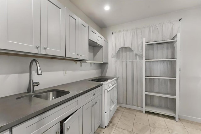 kitchen with white gas stove, sink, white cabinets, and light tile patterned floors