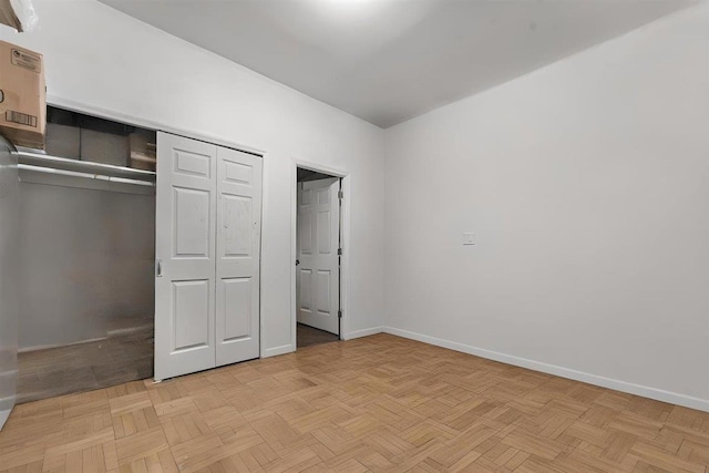 unfurnished bedroom featuring light parquet floors and a closet