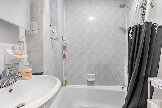 bathroom featuring sink, shower / tub combo with curtain, and tile walls