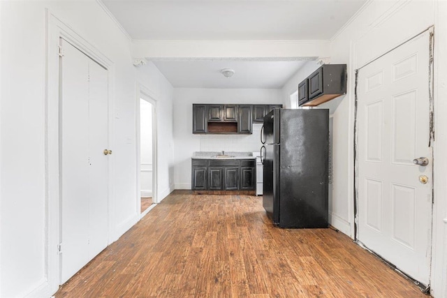 kitchen with black refrigerator, sink, ornamental molding, tasteful backsplash, and dark hardwood / wood-style floors