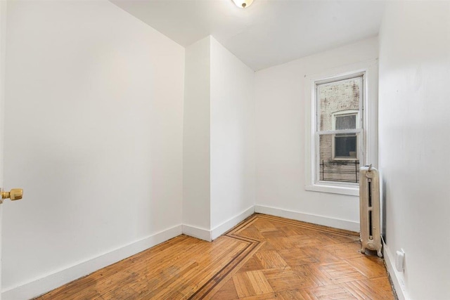 empty room featuring light parquet flooring and radiator heating unit