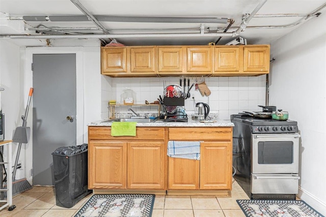 kitchen with sink, stainless steel electric range, tasteful backsplash, and light tile patterned floors