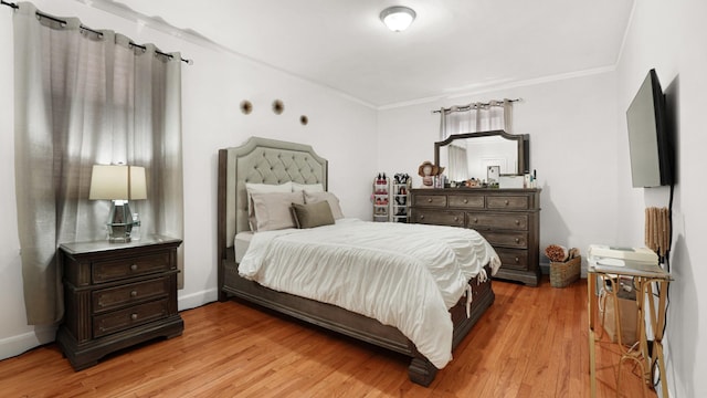 bedroom with ornamental molding and light wood-type flooring