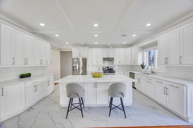 kitchen with a breakfast bar, a center island, white cabinets, and appliances with stainless steel finishes