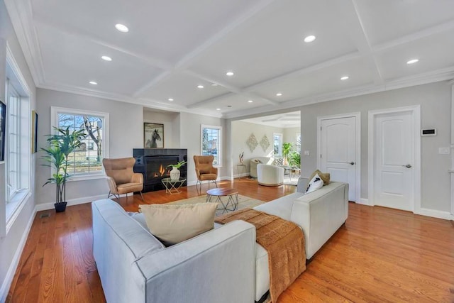 living room featuring ornamental molding, coffered ceiling, beam ceiling, and light hardwood / wood-style flooring