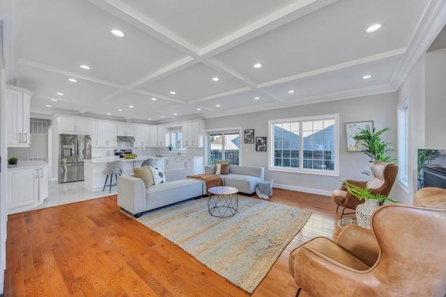 living room featuring ornamental molding, coffered ceiling, beam ceiling, and light hardwood / wood-style flooring