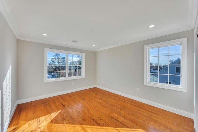 empty room featuring ornamental molding and light hardwood / wood-style floors