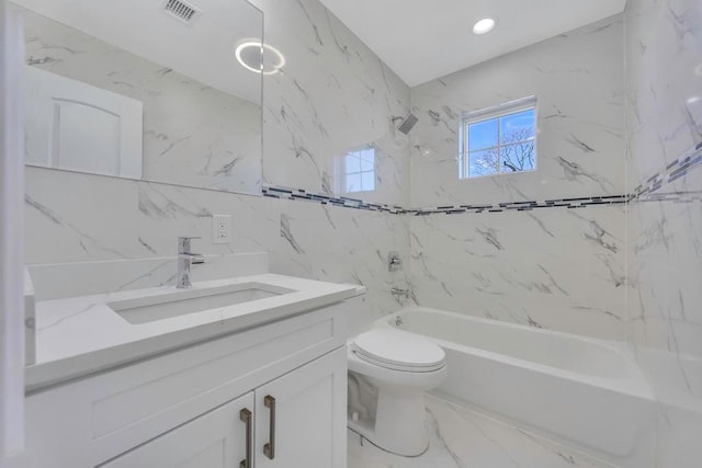 full bathroom featuring vanity, tile walls, toilet, and tiled shower / bath