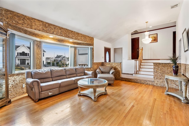 living room featuring lofted ceiling and light wood-type flooring