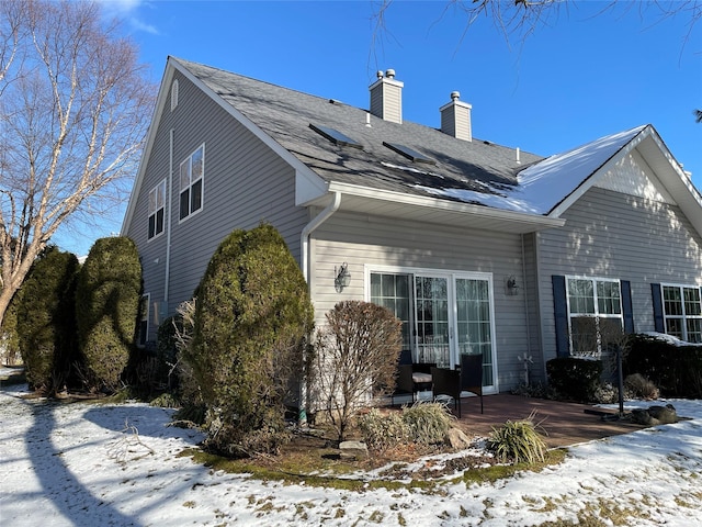 view of snow covered back of property