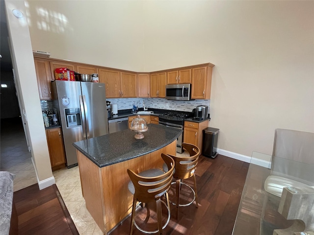 kitchen featuring tasteful backsplash, sink, a high ceiling, a center island, and stainless steel appliances