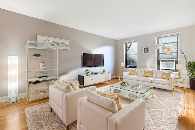 living room with cooling unit and light hardwood / wood-style flooring