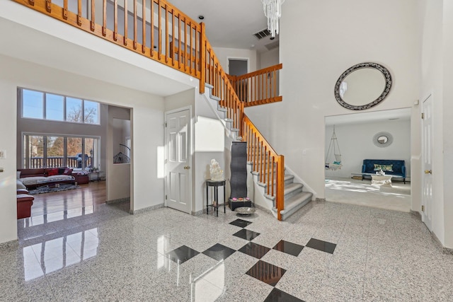 stairway featuring a towering ceiling