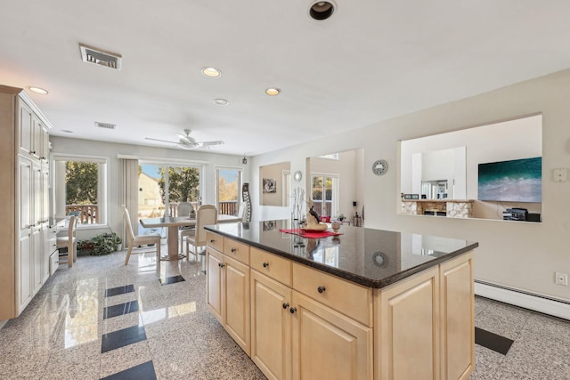 kitchen featuring a baseboard radiator, a center island, ceiling fan, and light brown cabinetry