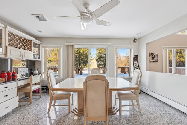 dining room with built in desk, ceiling fan, and baseboard heating