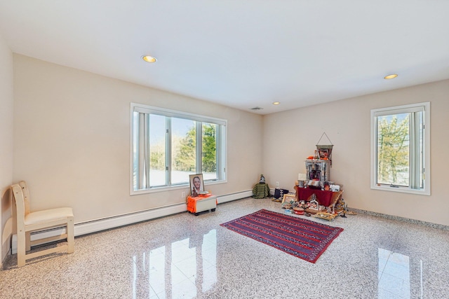 recreation room featuring a baseboard radiator and a healthy amount of sunlight