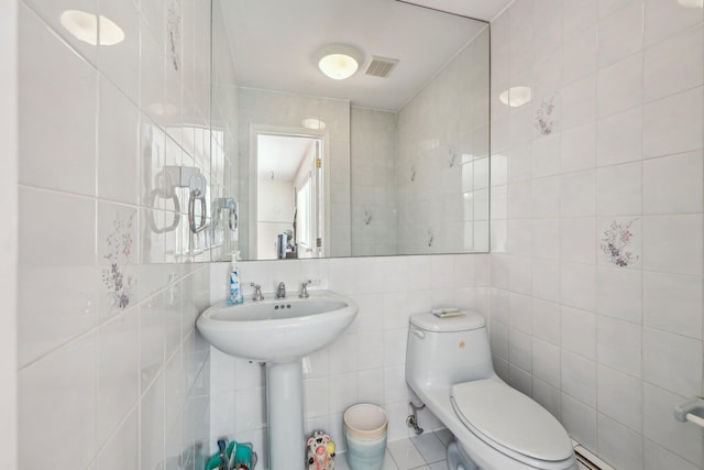 bathroom with toilet and tile walls