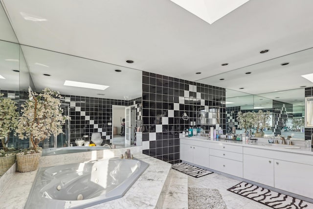 bathroom featuring shower with separate bathtub, a skylight, tile walls, vanity, and tile patterned floors