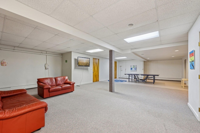 basement with a baseboard radiator, carpet, and a paneled ceiling