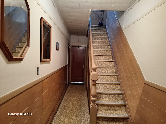 stairway featuring tile walls