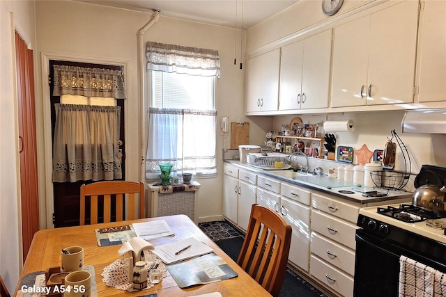 kitchen with white cabinetry, sink, and black range with gas stovetop